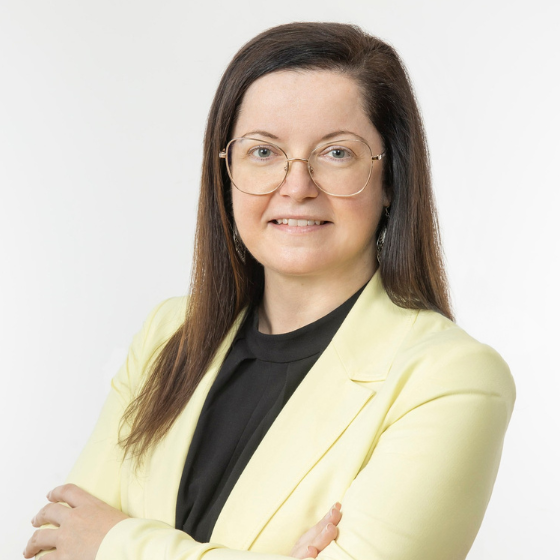 Simone Pfeiffer. Frau mit mittellangen braunen Haaren in gelbem Blazer und Brille