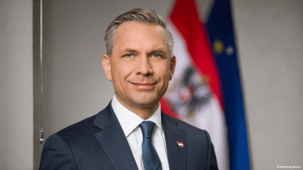 Minister Mag. Wolfgang Hattmannsdorfer Portraitfoto im Hintergrund Österreich und EU Flagge
