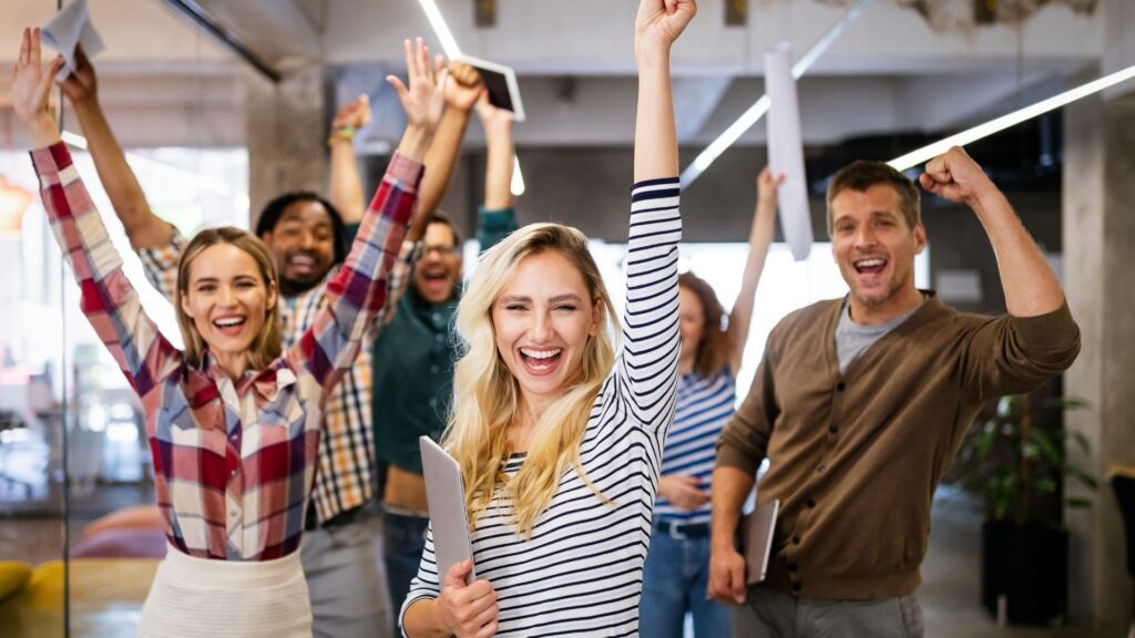 Das Bild zeigt mehrere Personen in einem modernen Büro- oder Arbeitsumfeld mit erhobenen Armen und Arbeitsunterlagen in der Hand. Es eignet sich als Symbolbild für Neugründungen, Selbständigkeit, Unternehmergeist und wirtschaftliche Aufbruchsstimmung. Im Zusammenhang mit dem neuen Gründungsrekord in der Steiermark unterstreicht das Motiv die Bedeutung von Eigenverantwortung, Innovationskraft und Engagement für den Wirtschaftsstandort Steiermark. Der Wirtschaftsbund Steiermark setzt sich dafür ein, dass neue Unternehmen und Selbständige verlässliche Rahmenbedingungen, weniger Bürokratie und mehr Planungssicherheit vorfinden.