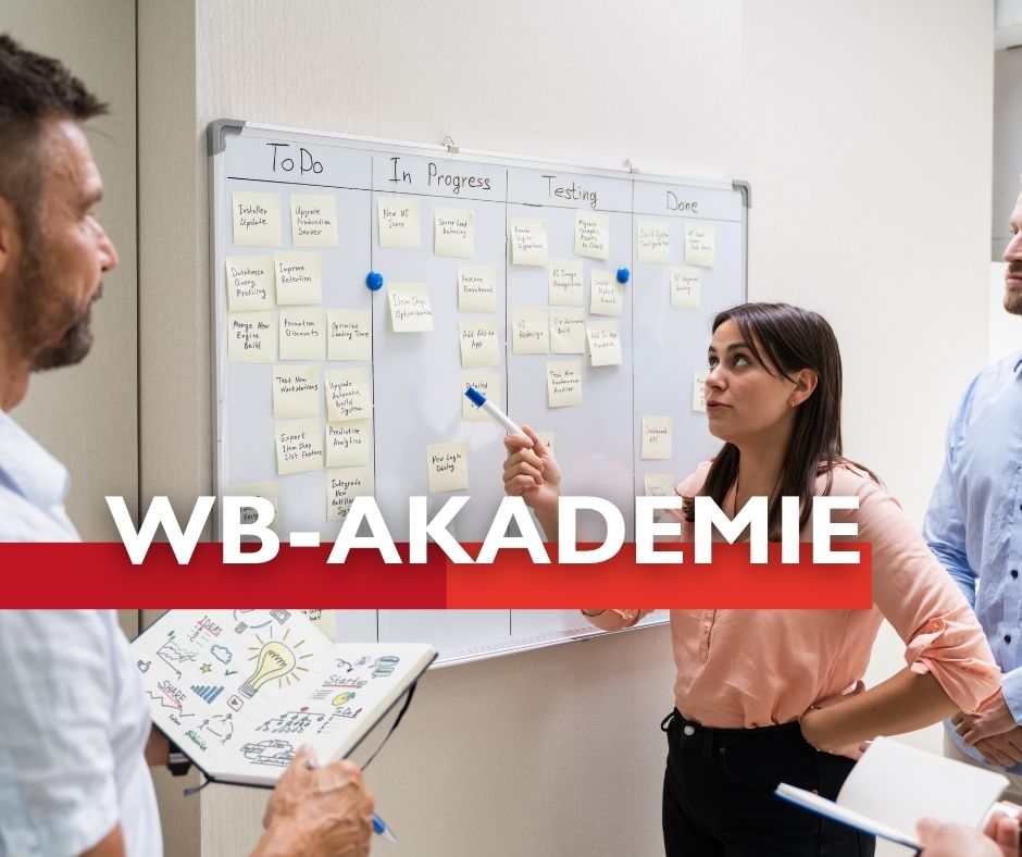 Frau präsentiert vor einer Gruppe an einem Whiteboard mit Aufgabenübersicht.