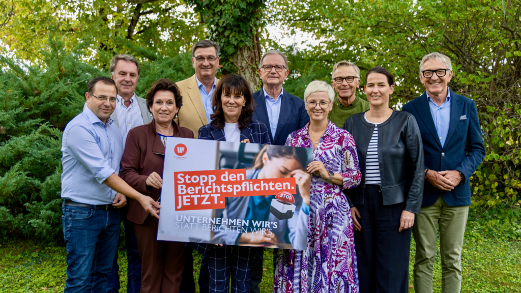 Vertreterinnen und Vertreter des Wirtschaftsbundes Steiermark präsentieren eine Kampagne gegen übermäßige Berichtspflichten. Auf dem Plakat steht „Stopp den Berichtspflichten. JETZT.“ und „Unternehmen wir's statt berichten wir's“.
