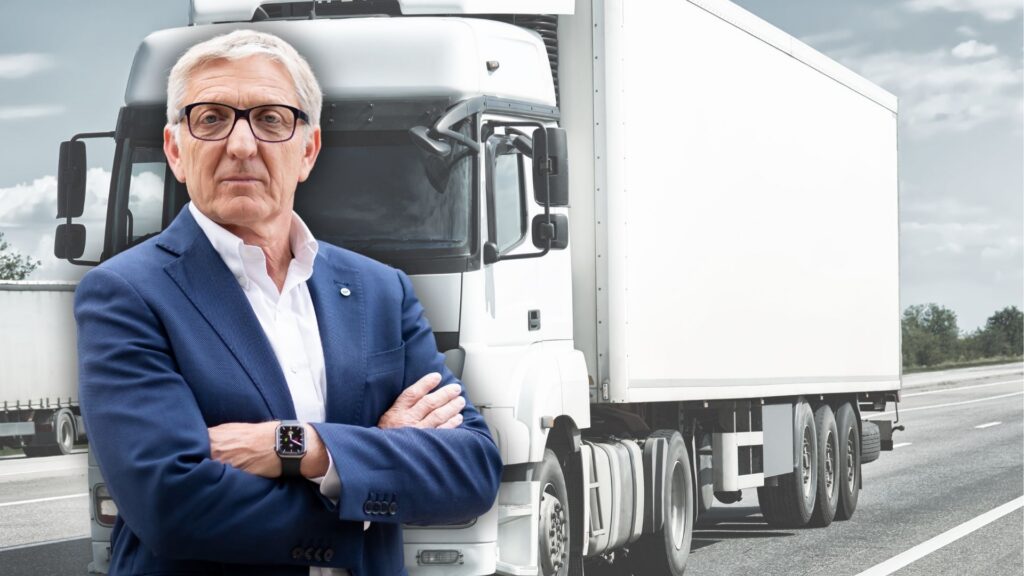 Präsident Obmann Herk im Portrait vor einem LKW.
