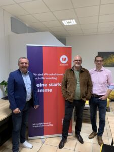 Drei Personen vor einem Roll-up des Wirtschaftsbundes Bruck-Mürzzuschlag in Räumlichkeiten der SAM GmbH.